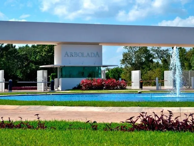 Acceso principal con fuente y jardines de Residencial Arbolada